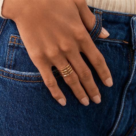 Photo d'une femme portant une bague large Agatha imposante et stylée, comme pièce maîtresse de sa tenue.