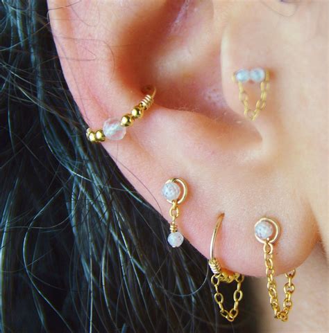 Vue rapprochée d'une oreille ornée de plusieurs piercings harmonieusement disposés