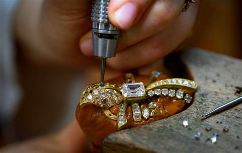 Photo d'un artisan joaillier travaillant sur un bijou en argent dans son atelier.
