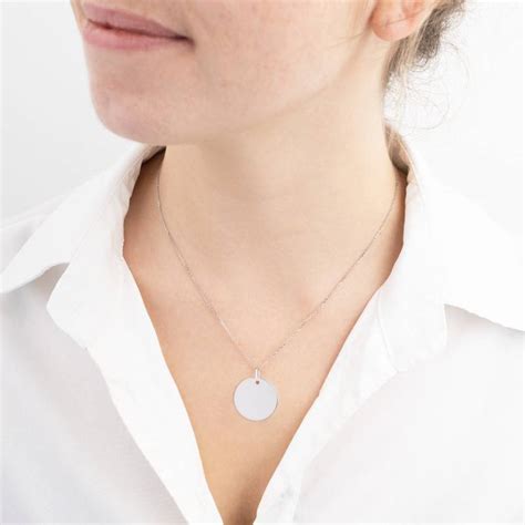 Gros plan sur une médaille ronde en argent 925 avec un motif cœur et l'inscription 
