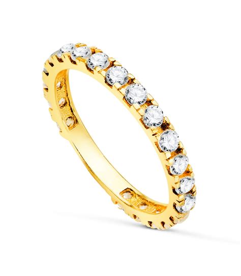 Une bague de mariage en or jaune avec plusieurs petites zircones blanches serties sur l'anneau.