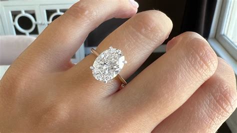 Une bague de fiançailles solitaire avec un diamant central entouré d'un halo de petits diamants