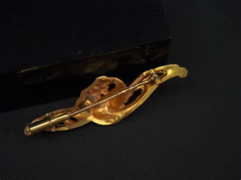 Schéma illustrant les différentes parties d'une broche ancienne (attache, corps, fermoir)