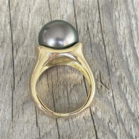 Photographie d'une bague plaquée or avec une perle oeil en céramique et une pierre Swarovski gris fumé