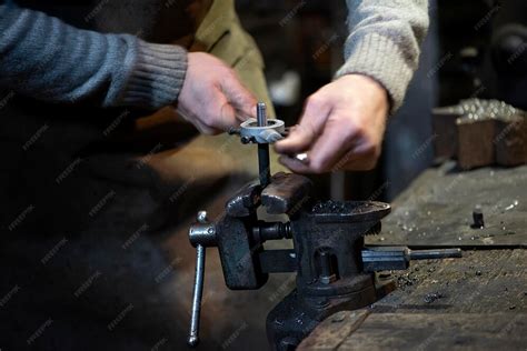 Photographie d'un artisan Christofle travaillant le métal à la main