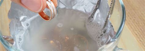 Image montrant un kit d'entretien pour bijoux en argent, incluant un chiffon, une brosse et un produit nettoyant.