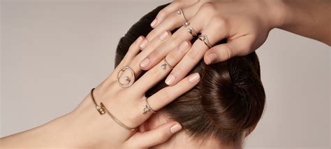 Illustration montrant différentes combinaisons de bagues Pandora superposées sur une main.