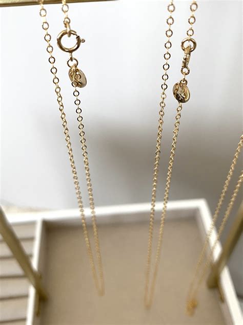 Schéma montrant la composition d'une chaîne en or avec un pendentif perle, mettant en évidence la monture et la perle.