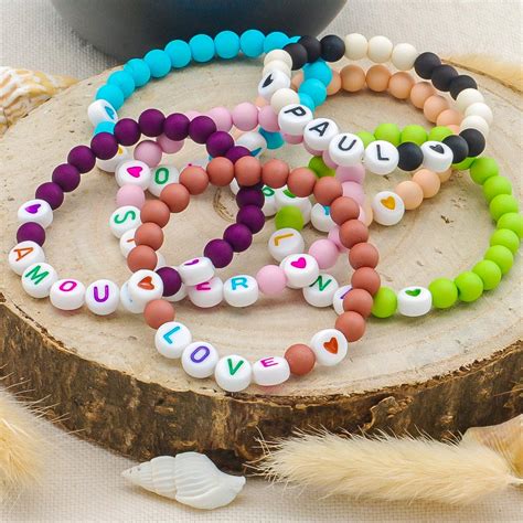 Des bracelets ornés de perles multicolores et de charms en forme de plume