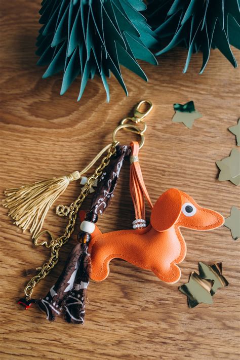 Exemple de grigri de sac avec un pendentif teckel, un bandana noué et des breloques dorées.
