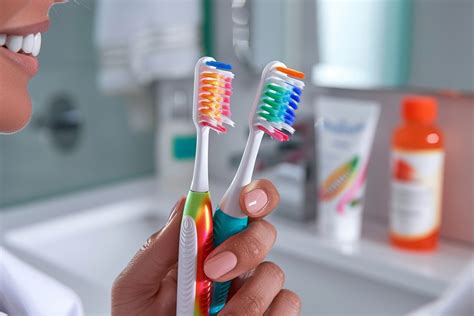 Une personne nettoyant délicatement des coquillages avec une brosse à dents.