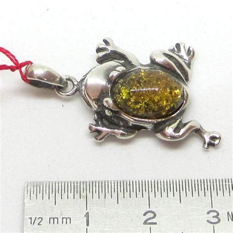 Une grenouille en argent 925, finement ciselée, posée sur un nénuphar, symbolisant la nature et la préciosité du bijou.
