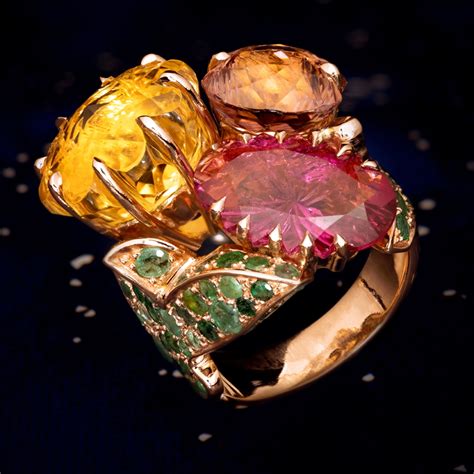 Photographie d'une bague spectaculaire de haute joaillerie avec des pierres de couleur vives.