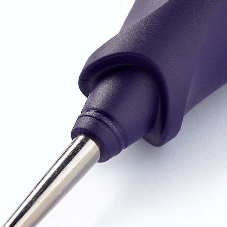 Gros plan sur le manche ergonomique du poinçon et le protège-pointe transparent.