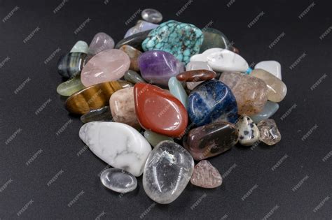 Diverses pierres polies naturelles de différentes couleurs et tailles, disposées harmonieusement sur un fond neutre.