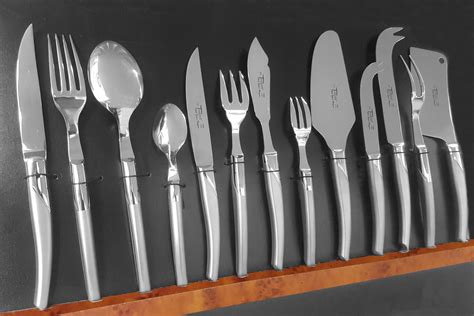 Illustration d'une ménagère complète avec ses différentes pièces : couverts de table, couverts à dessert, louche, pelle à tarte.
