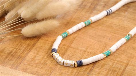 Enfant souriant portant un collier surfeur avec des perles colorées