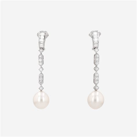 Gros plan sur des boucles d'oreilles Tiffany en diamants et en perles, mettant en valeur leur éclat et leur finesse.
