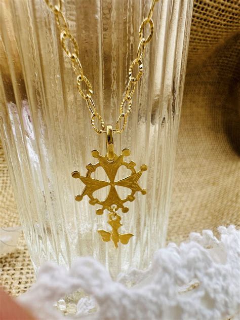 Collage de photos de différents types de bijoux proposés par La Maison Gabriel : croix huguenote, médaille personnalisée, pendentif plaque, croix humilité.