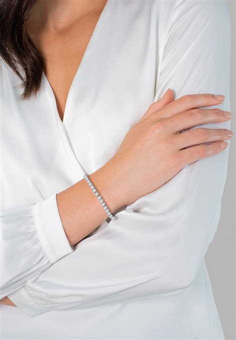 Une femme portant un élégant bracelet en argent à son poignet, complétant une tenue de soirée.