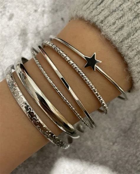 Collection variée de bracelets en argent pour femme, incluant gourmettes, joncs et bracelets chaîne.