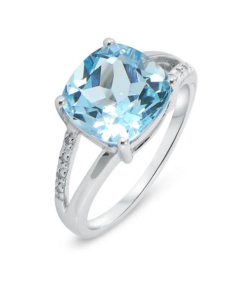 Photographie d'une bague élégante en or jaune sertie d'une topaze bleue centrale et de petits diamants.