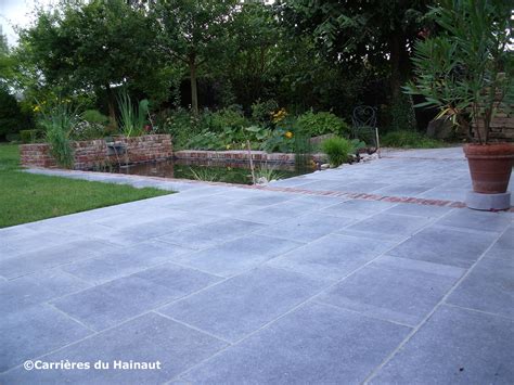 Visuel mettant en scène une terrasse en Pierre Bleue du Hainaut avec un aspect patiné et vieilli, soulignant sa durabilité et son charme.