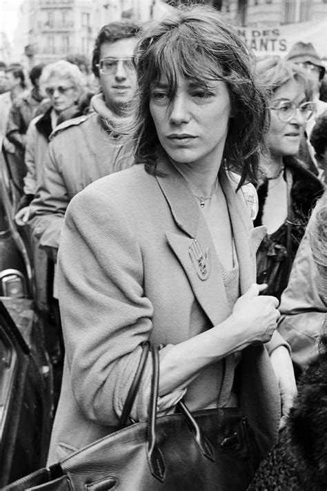 Photographie d'archives de Jane Birkin avec son sac Birkin, symbolisant son statut d'icône