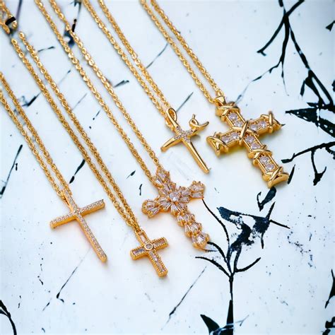 Galerie de colliers croix pour hommes, femmes et enfants, mettant en avant différents styles et matériaux