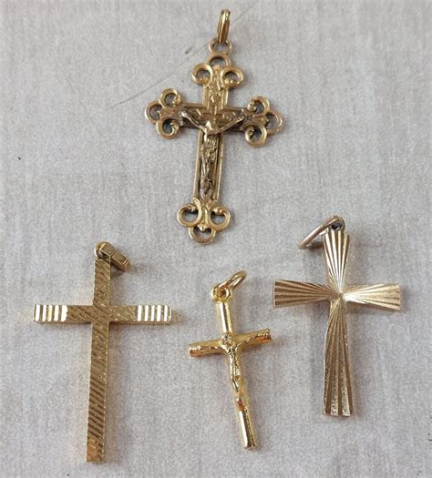 Gros plan sur des pendentifs croix en or blanc et or jaune, mettant en évidence leurs textures et finitions.