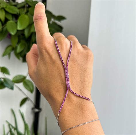 Photo d'une femme portant une délicate chaîne de main en argent sur un poignet fin.