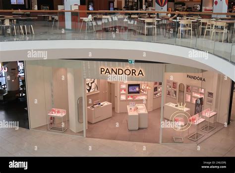 Ambiance intérieure d'une boutique Pandora dans un outlet, avec des bijoux bien exposés et un éclairage chaleureux.