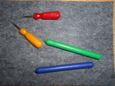 Matériel de poinçonnage : poinçon, tapis de feutrine et cartes à perforer.