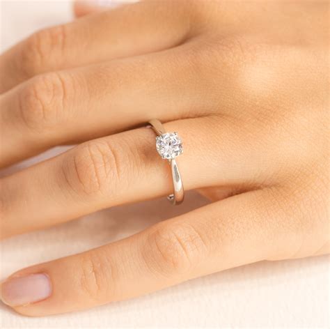 Une main portant une bague de fiançailles solitaire classique