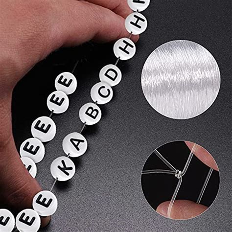 Photo montrant l'enfilage de perles alphabet sur du fil élastique