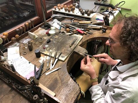 Photographie d'un atelier de bijouterie français montrant des artisans au travail sur des bijoux en argent et or.