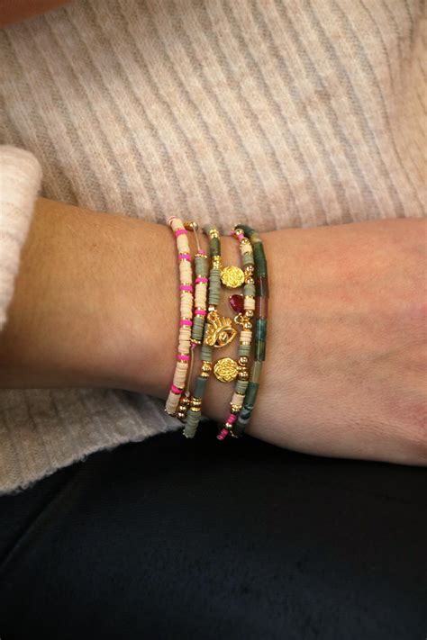 Exemple de superposition de bracelets fins en or avec des perles