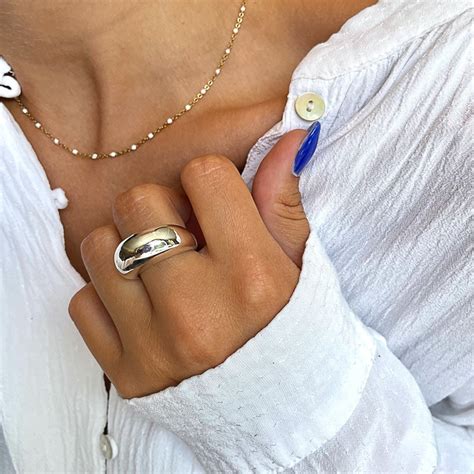 Gros plan sur une bague en argent ornée d'une pierre d'onyx lisse et polie.