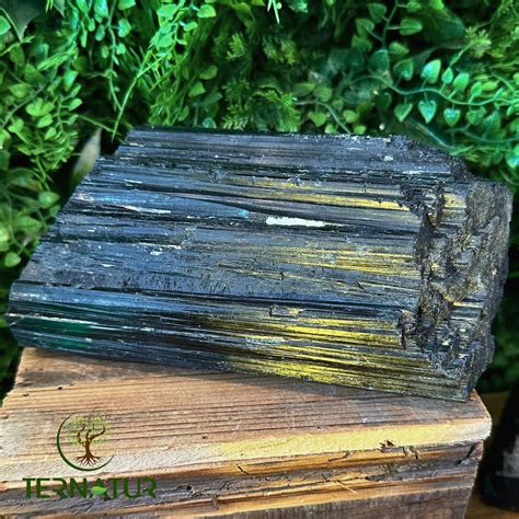 Vue rapprochée d'une tourmaline Paraíba brute et polie, mettant en évidence sa couleur bleu-vert électrique unique.