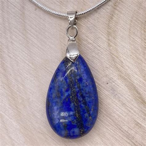 Exemple de bijou en lapis lazuli, tel qu'un pendentif ou une bague, mettant en valeur sa couleur bleue intense et ses inclusions dorées.