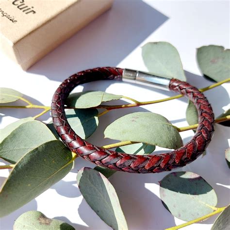 Gros plan sur la texture du cuir tressé et les finitions métalliques d'un bracelet de luxe