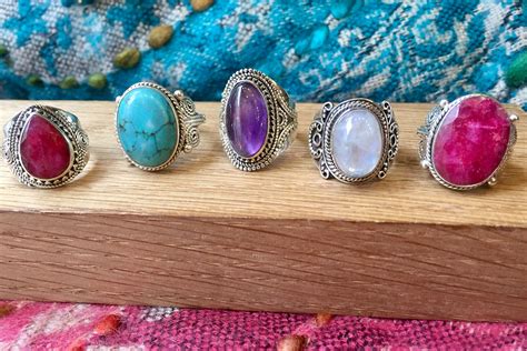 Une main ornée d'une bague élégante avec une grosse pierre colorée