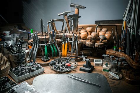 Photographie de Fabien Cardona dans son atelier, manipulant des outils de joaillerie.