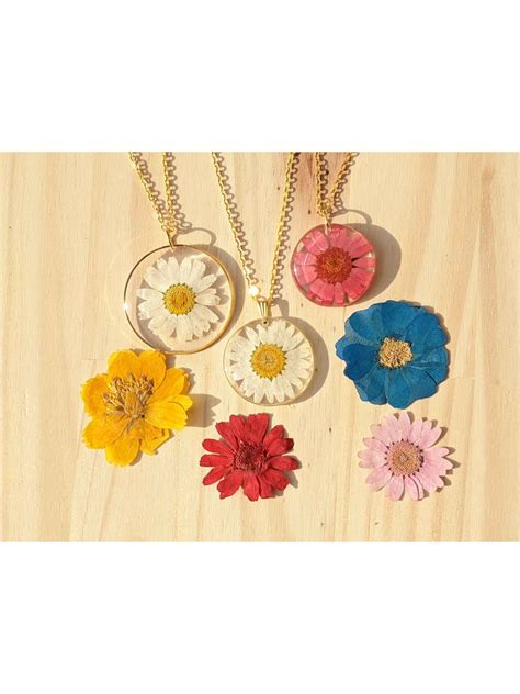 Détail du collier avec marguerite en résine et pendentif rond en bronze, soulignant sa finesse.