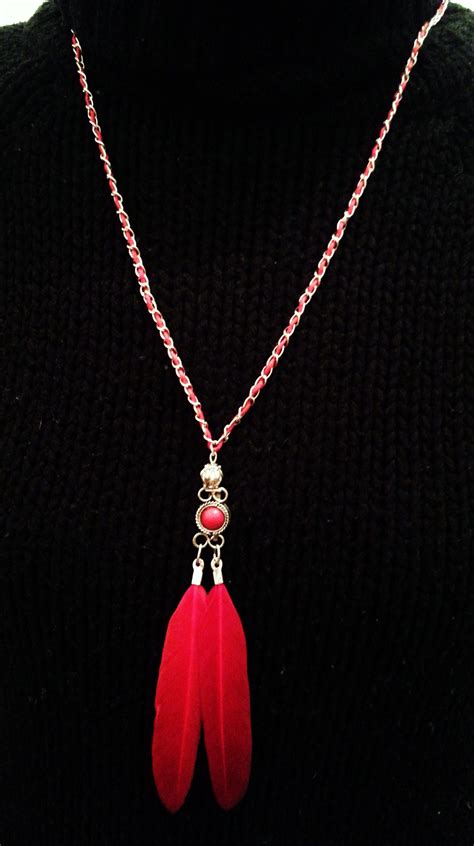 Le sautoir avec perle centrale rouge, présenté de manière à montrer son allure audacieuse.