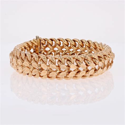 Un bijoutier expert examine un bracelet ancien en or pour en certifier l'authenticité.