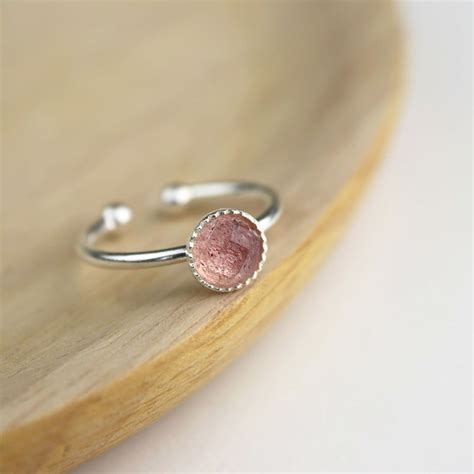 Une bague en argent 925 avec une pierre de quartz fraise délicatement facettée, mettant en valeur ses teintes rosées.