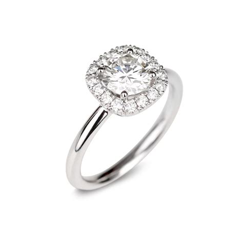 Photographie d'une bague de fiançailles solitaire ornée d'un diamant central et d'un halo de diamants plus petits.