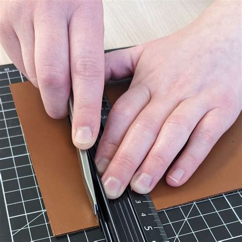 Différents outils pour la découpe du cuir : ciseaux, cutter rotatif, règle de coupe, machine de découpe