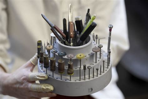 Photographie d'un graveur travaillant sur une pièce de joaillerie avec des outils de précision.